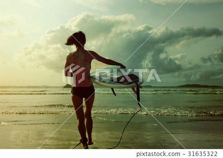 young woman surfer ready to surf on a beach young woman surfer ready to surf on a beach 31635322