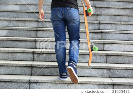 skateboarder walking upstairs with a skateboard skateboarder walking upstairs with a skateboard 31635421