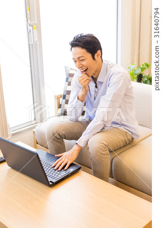 使用膝上型計算機的場面在客廳，男性 31640794