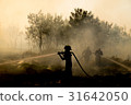 Smoke field and fireman after wildfire sihouette. 31642050
