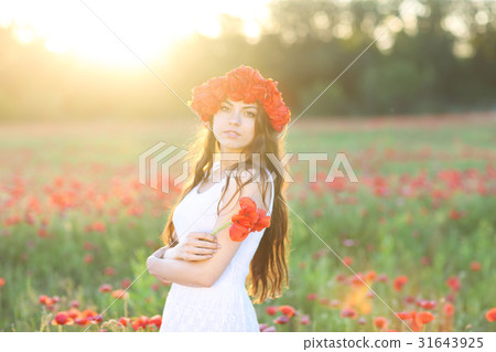Young happy woman in poppy field Young happy woman in poppy field 31643925