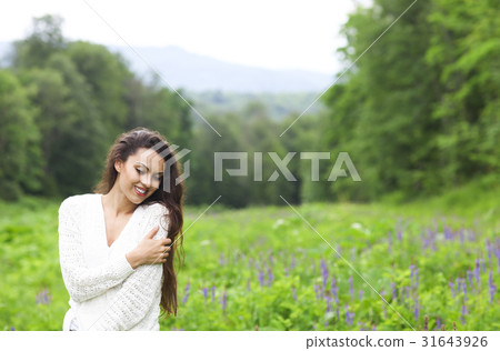 Happy pretty brunette woman in flower field Happy pretty brunette woman in flower field 31643926
