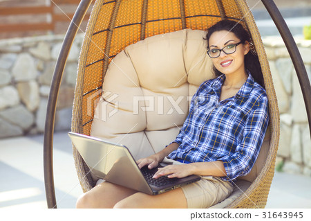 Young woman working on computer outdoors 31643945