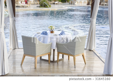 Dinner table for couple by pool Dinner table for couple by pool 31645160