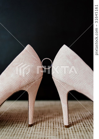 Wedding ring between the bride's shoes on dark Wedding ring between the bride's shoes on dark 31645161
