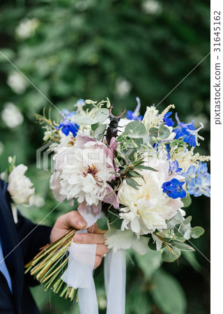 The groom holding wedding bouquet of peonies The groom holding wedding bouquet of peonies 31645162