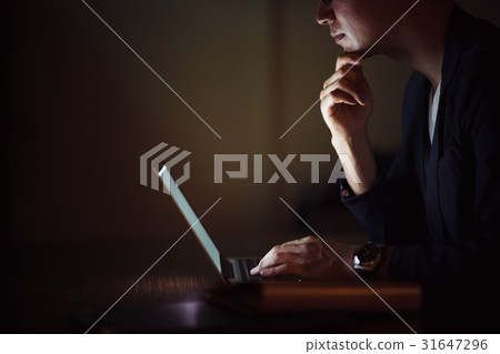 Male who uses a computer at night Male who uses a computer at night 31647296