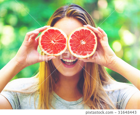 Happy young woman holding grapefruit 31648443