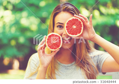 Happy young woman holding grapefruit Happy young woman holding grapefruit 31648444