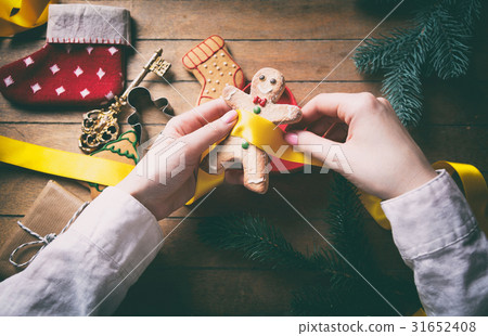 hands wrapping christmas gifts and cookies 31652408
