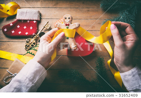 hands wrapping christmas gifts and cookies 31652409