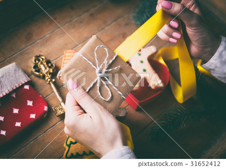 hands wrapping christmas gifts and cookies 31652412