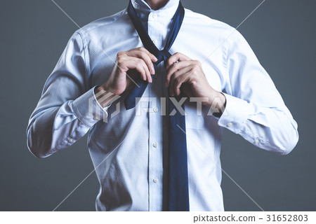 A man tying a tie A man tying a tie 31652803