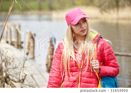 Joyful blond girl dressed in sport with poles Nordic walking on 31654950