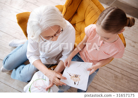 Nice happy woman looking at her granddaughters Nice happy woman looking at her granddaughters 31657175