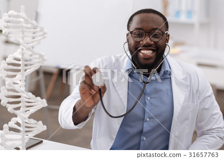 Cheerful friendly doctor holding a stethoscope 31657763