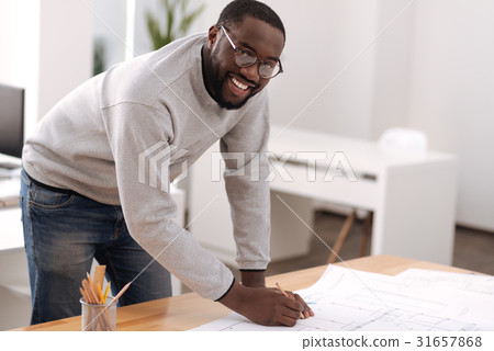 Joyful positive man doing a draft Joyful positive man doing a draft 31657868