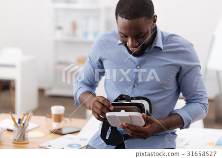 Happy nice man preparing 3d glasses for usage Happy nice man preparing 3d glasses for usage 31658527