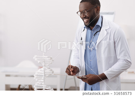 Smart handsome scientist studying human DNA 31658573