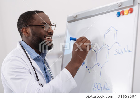 Handsome positive chemist writing a formula 31658594