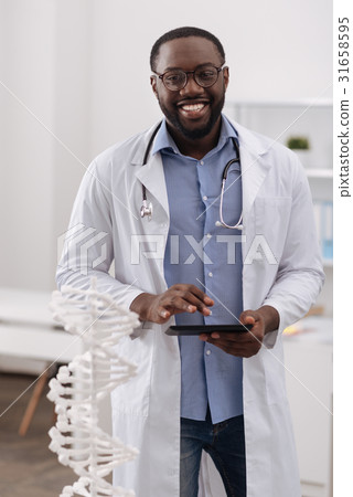 Cheerful handsome doctor enjoying his job 31658595
