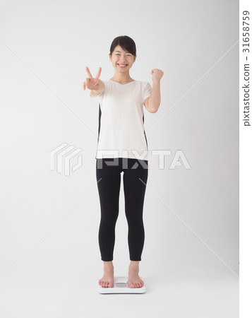 A woman glad to measure weight A woman glad to measure weight 31658759