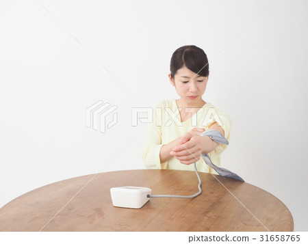 A woman measuring blood pressure A woman measuring blood pressure 31658765
