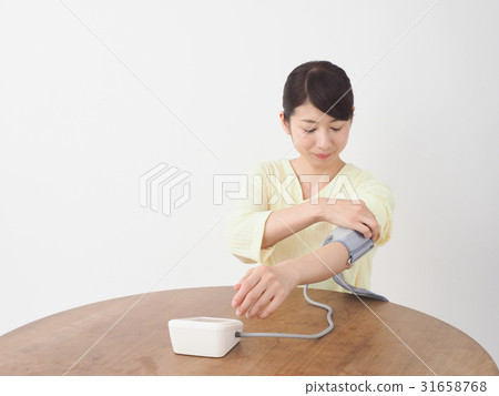 A woman measuring blood pressure A woman measuring blood pressure 31658768