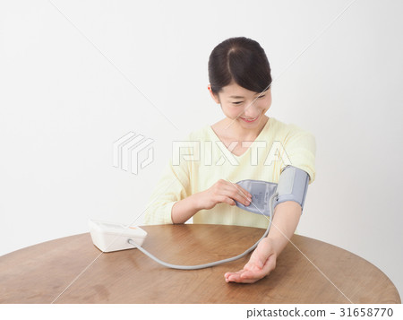 A woman measuring blood pressure 31658770
