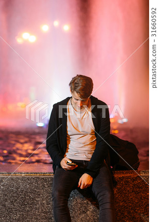 Smiling guy reading message on smartphone 31660592