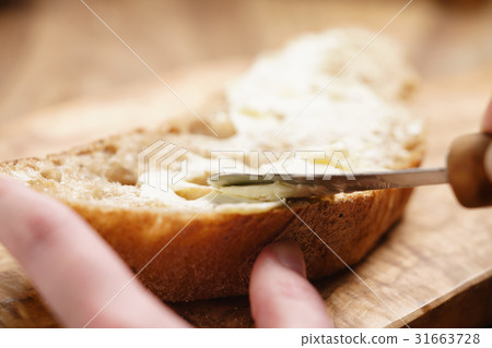 young female hands spreading butter on bread young female hands spreading butter on bread 31663728