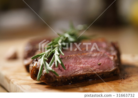 sliced medium rib eye steak with rosemary branch sliced medium rib eye steak with rosemary branch 31663732