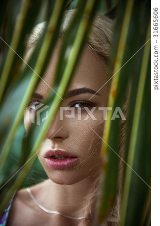 Portrait of girl on background of palm leaf 31665606