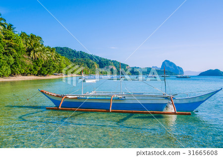 Traditional banca boat in clear water at sandy 31665608