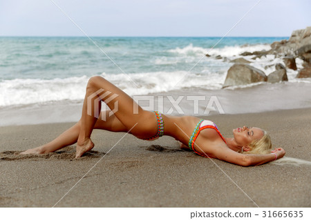 Bikini model posing sexy at tropical beach  31665635