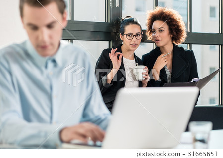 Two young women laughing behind their male 31665651