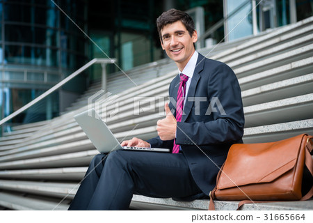 Successful young businessman showing thumb up Successful young businessman showing thumb up 31665664