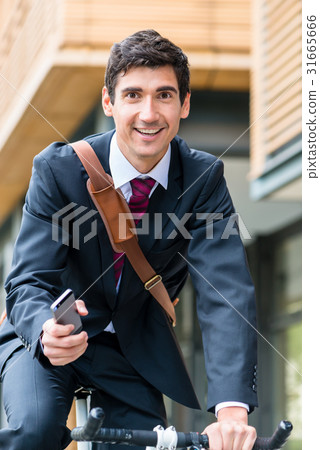 Multitasking young businessman riding a bicycle to Multitasking young businessman riding a bicycle to 31665666