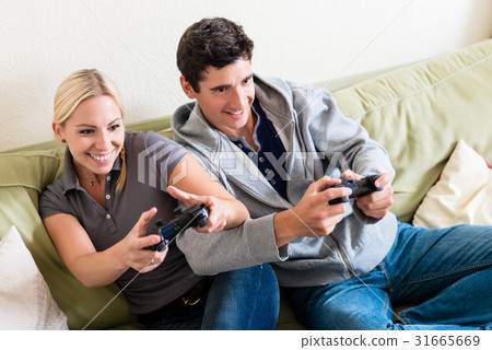 Funny young couple playing together a video game Funny young couple playing together a video game 31665669