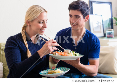 Young Caucasian couple eating Asian traditional Young Caucasian couple eating Asian traditional 31665672