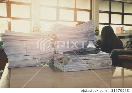 Pile of unfinished documents on office desk 31670928