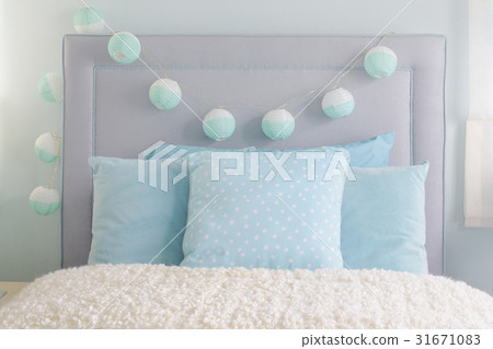 blue pillows with decorative ball on headboard 31671083