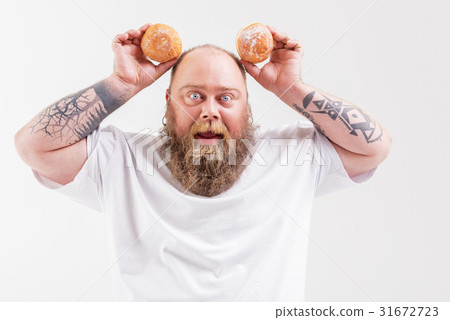 Carefree fat man playing with donuts 31672723
