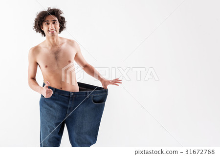 Cheerful slim man is satisfied with his body Cheerful slim man is satisfied with his body 31672768