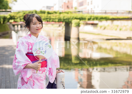 A woman walking through the streets of Hakata A woman walking through the streets of Hakata 31672979