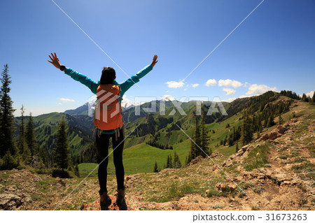 Cheering  woman hiker open arms on mountain top 31673263