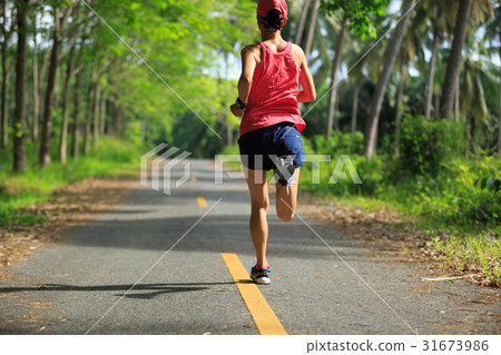 Young fitness woman running at forest trail Young fitness woman running at forest trail 31673986