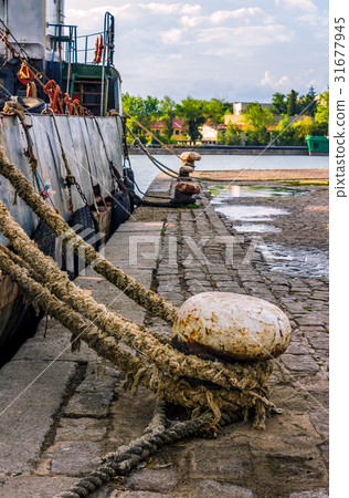 Boat docked to a mooring bollard at sunset Boat docked to a mooring bollard at sunset 31677945