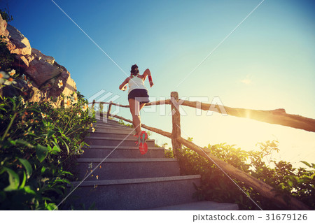 woman runner running upstairs on mountain stairs 31679126