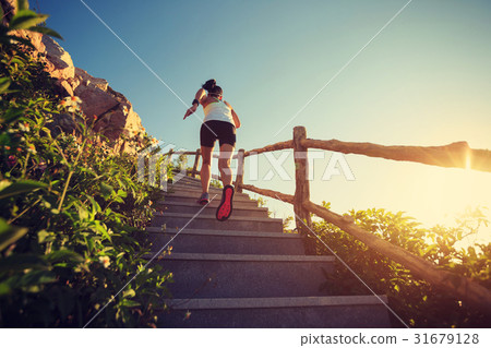 woman runner running upstairs on mountain stairs 31679128